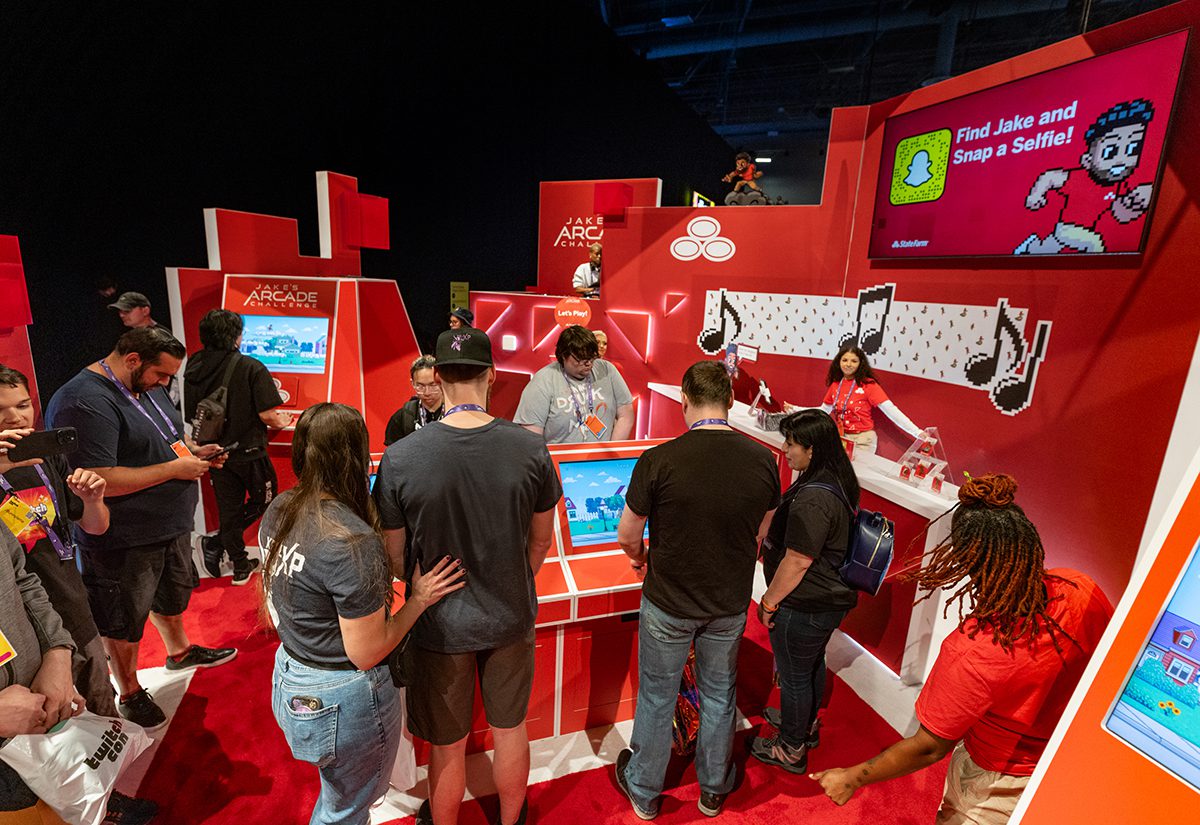 TwitchCon attendees gather around State Farm's arcade game consoles